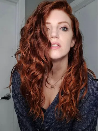 Try on long wavy auburn hair with light curling and natural flow, framing the face beautifully in a casual style.