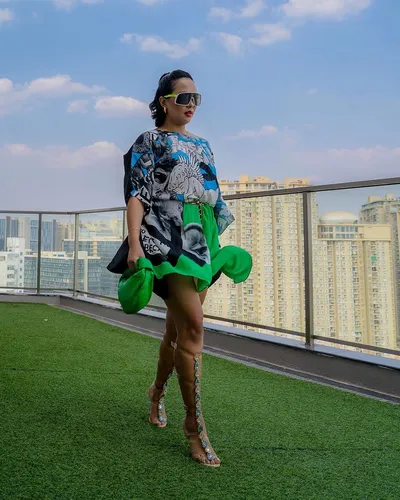 Try on this medium length wavy hairstyle visible on a woman standing outdoors on a rooftop.