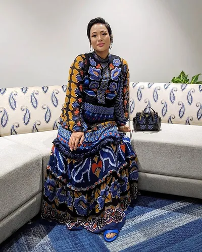 Try on a slicked-back hairstyle. The person in the image is wearing her hair in a polished, slicked-back style, adding a sophisticated look.