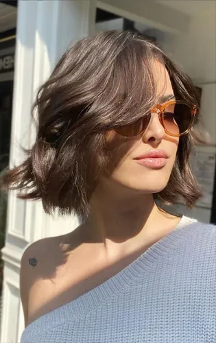 Try on this wavy bob hairstyle with subtle highlights, perfect for a fresh and stylish look.