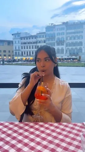 Try on this smooth long hairstyle, as seen on a woman sipping a drink at an outdoor venue.