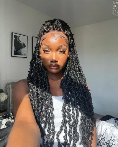 Try on this intricate long, curly hairstyle featured, cascading past the shoulders in tight, voluminous curls. The hairstyle includes elegantly sectioned parts on the top that add a stylish contrast to the dense curls.