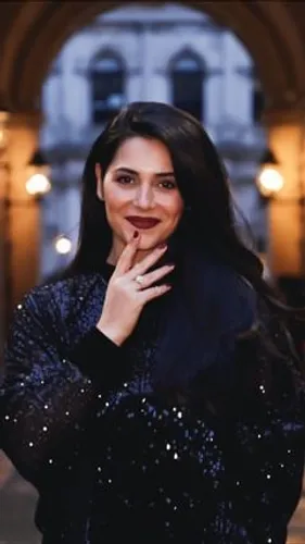 Try on this long straight hairstyle complemented by a shiny black party dress, posing with a thoughtful expression in a softly lit evening setting