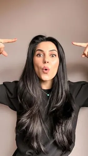 Try on this striking long, straight hairstyle as demonstrated by the woman pointing at her head