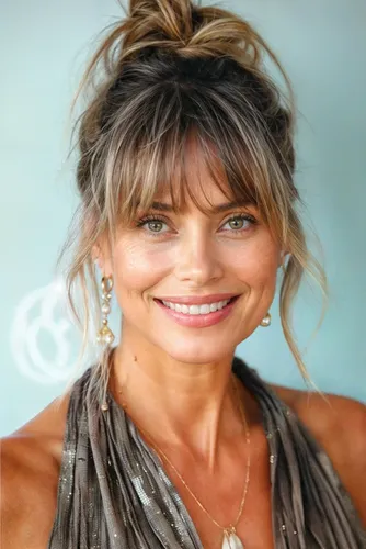 Try on this messy bun hairstyle, styled loosely with some strands hanging freely around the sides, giving a casual and relaxed appearance.