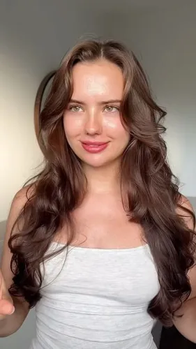 Try on this long wavy hairstyle with a side part, showcasing voluminous, glossy waves that cascade gracefully, creating a captivating and feminine appearance.