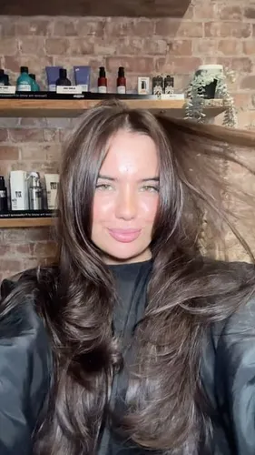 Try on this wavy hairstyle, featuring mid-length brown hair resting loosely with a natural wave.