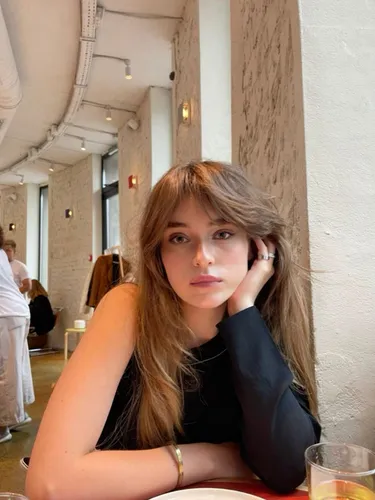 Try on this gentle long wavy hairstyle with a subtle fringe that blends seamlessly into the soft waves, creating a relaxed and effortlessly chic appearance. Ideal for those looking to channel a casual yet fashionable vibe.