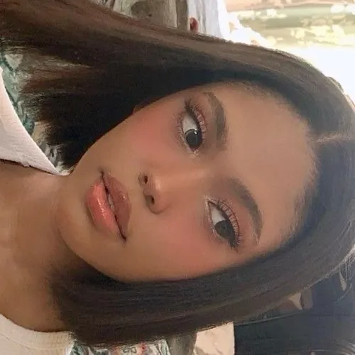 Try on a straight, medium-length hairstyle showcased by the person. The hair is parted on the side and falls gently around the face, framing it softly.