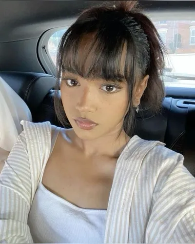 Try on this hairstyle featuring a sleek ponytail with straight bangs, offering a youthful and chic appearance.