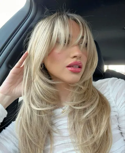 Try on this elegant long layered hairstyle with blonde highlights, perfect for adding volume and style.
