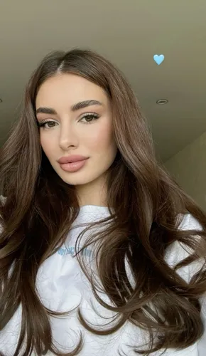 Try on this beautiful long wavy hairstyle in light brown color, offering a stunning cascade of curls that add volume and elegance.