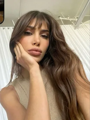 Try on soft, long hair with wispy bangs caressing the forehead, framing the face elegantly