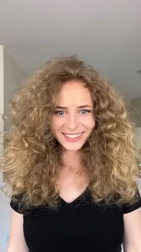 Try on this voluminous curly hairstyle that frames the face beautifully with its rich texture and fullness.