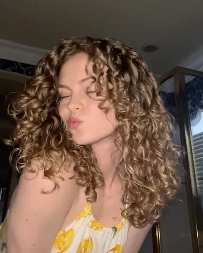 Try on this voluminous curly hairstyle, featuring tight, well-defined curls that add a lot of texture and movement.
