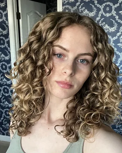 Try on this curly, blonde hairstyle, featuring tight curls that add volume and texture