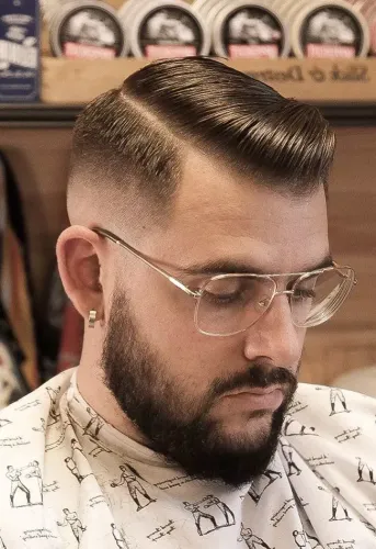 Try on a slicked back hairstyle with a fade on the sides, neatly combed with shine, suitable for a polished look.