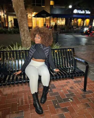 Try on a hairstyle with voluminous curly afro that frames the face beautifully. The curls are dense and well-defined, adding a playful yet elegant touch to the look.