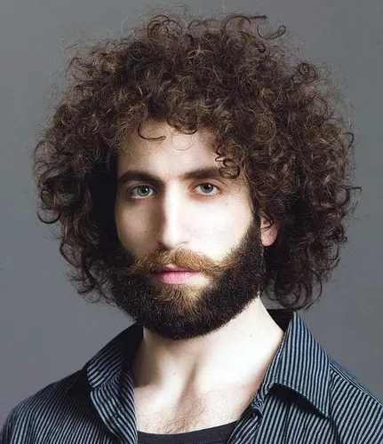Try on a thick curly hairstyle combined with a full beard, perfect for experimenting with a bold, textured look.