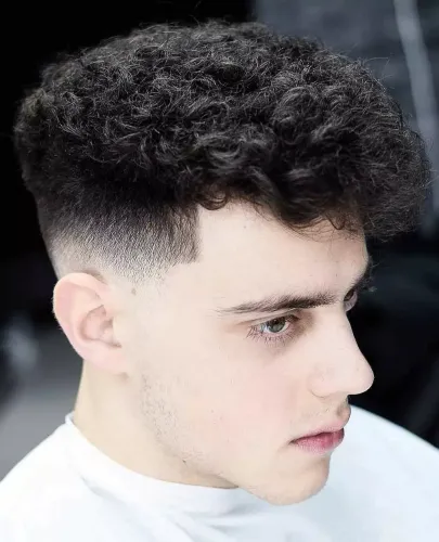 Try on a trendy hairstyle featuring a curly top with a tight fade on the sides.
