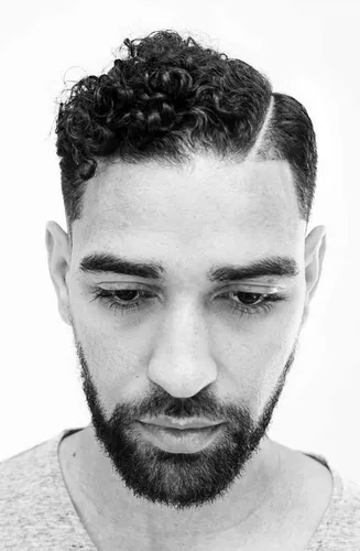 Try on this hairstyle featuring tight curly hair on top with a clear fade on the sides.