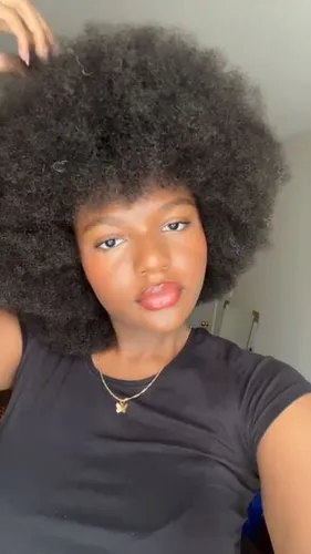 Try on a voluminous afro hairstyle, showcasing an impressive, large, and fluffy texture that frames the face beautifully. The hairstyle is thick and well-defined, adding a striking and stylish look.