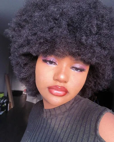 Try on this voluminous, dense Afro hairstyle that beautifully frames the face, enhancing the overall facial features.