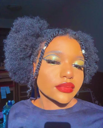 Try on a voluminous afro hairstyle with tight curls and a dense texture, providing a full and fluffy look.