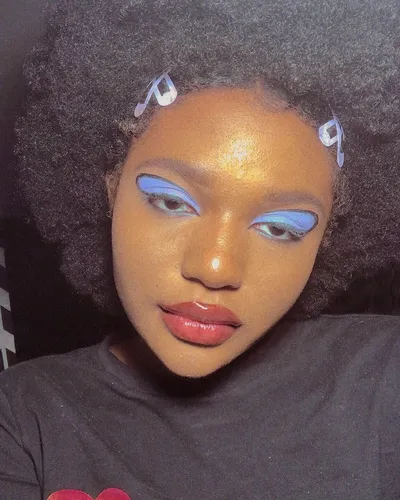 Try on a curly and voluminous hairstyle visible on the person in the image