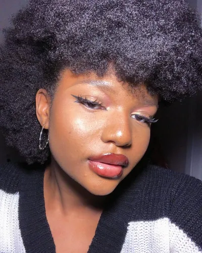Try on this voluminous afro hairstyle, featuring dense, tightly coiled curls that add a significant amount of volume and texture.