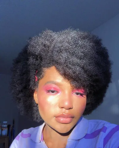 Try on this vibrant afro hairstyle that includes curly, voluminous textures, creating a full and expressive look.