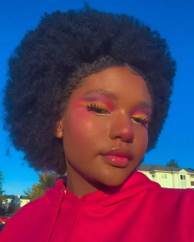 Try on a voluminous afro hairstyle in this close-up image featuring a person with a natural, dense and rounded afro hair texture, creating a stylish and powerful look.