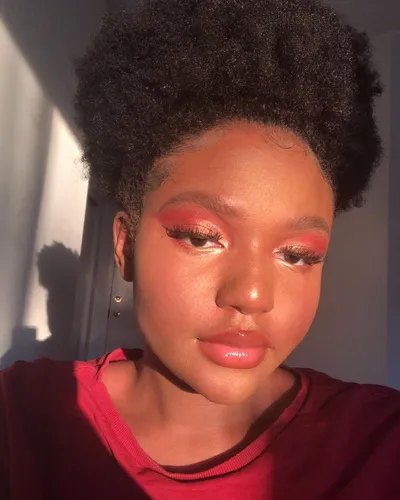 Try on a natural afro hairstyle, featuring tightly coiled hair texture that forms a voluminous appearance.