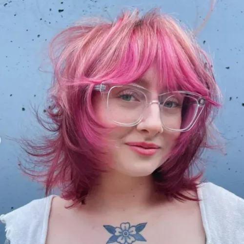 Try on this vibrant pink hairstyle with short, wavy layers, complementing a playful and modern look.