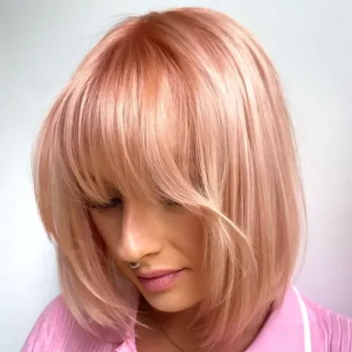 Try on a chic pink bob cut with subtle bangs, evoking a soft and stylish look.