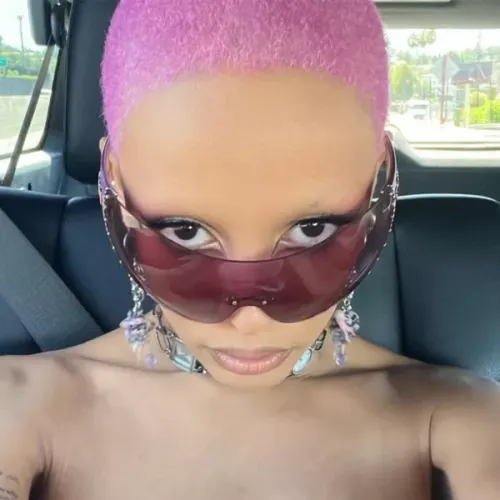 try on a vibrant pink buzz cut hairstyle, accentuated by stylish oversized sunglasses