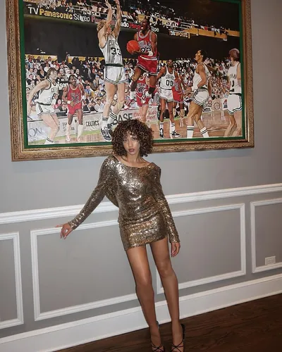 Try on this curly, medium-length hairstyle featuring tight, voluminous curls that cascade around the face, adding a touch of glamour perfect for a dazzling evening event.