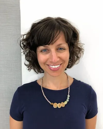 Try on this cheerful style featuring natural-looking short curly hair.