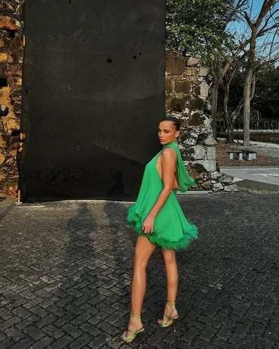 Try on a sleek bun hairstyle as showcased by the woman in a green dress, emphasizing a tidy and elegant look ideal for formal or festive occasions.