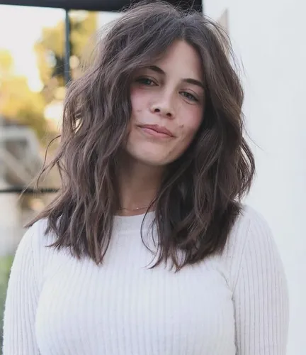 Try on this wavy, medium-length hairstyle that casually frames the face, offering a relaxed and stylish look.