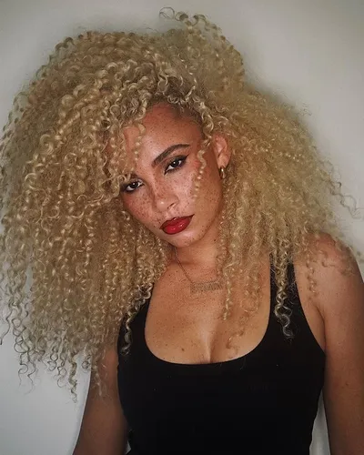 Try on this luxurious long, voluminous curly hairstyle that cascades down the shoulders.