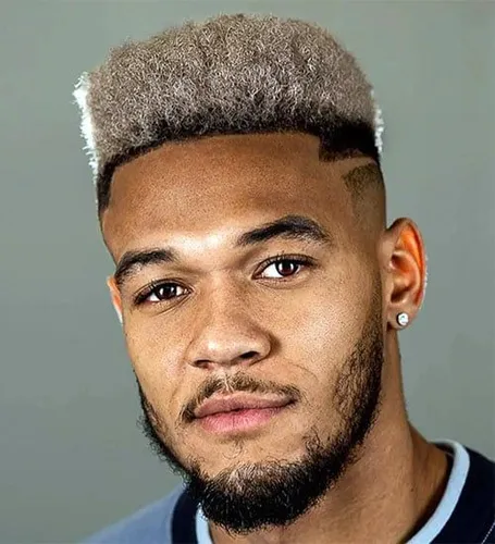 Try on this striking high-top fade hairstyle, featuring neatly faded sides blending into a textured, voluminous top with a lighter color tone that stands out.