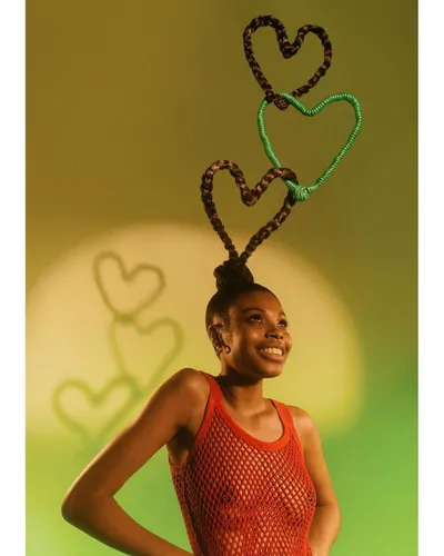 Try on this unique, creative hairstyle featuring braids styled into heart-shaped designs, adding a playful and artistic touch to the look.
