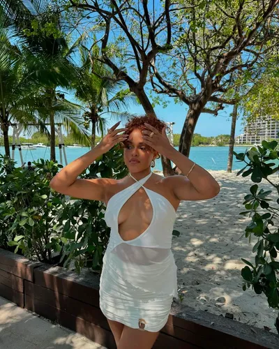 Try on a short, curly hairstyle with voluminous texture and natural curls, styled upward for a playful and expressive look.