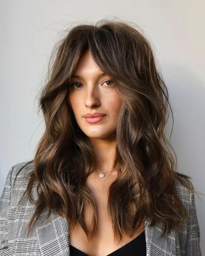 Try on this medium-length wavy hairstyle, featuring smooth waves with subtle highlights adding texture and dimension.