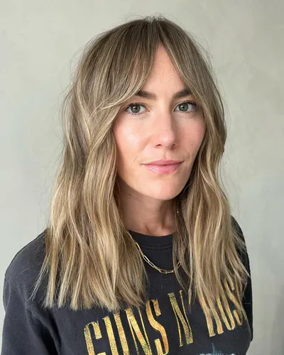 try on a style featuring long wavy hair with blonde highlights and soft layers, adding texture and movement