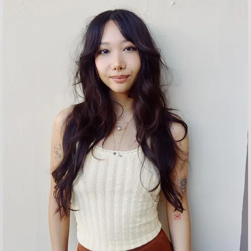 Try on this long, wavy hairstyle cascading over a cream top, styled to enhance the natural texture and volume.