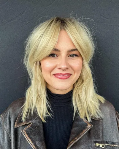 Try on this tousled, medium-length blonde hairstyle with natural roots showing, giving a relaxed and stylish look.