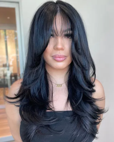 Try on this long, wavy black hairstyle with subtle layers that add volume and movement.