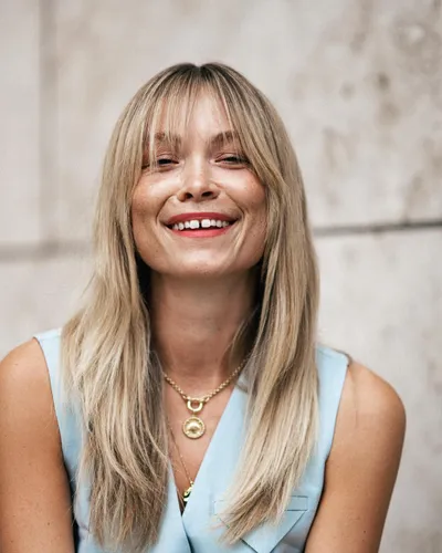 Try on this long, straight hairstyle that gently flows past the shoulders, featuring subtle layers for a sleek, polished look.
